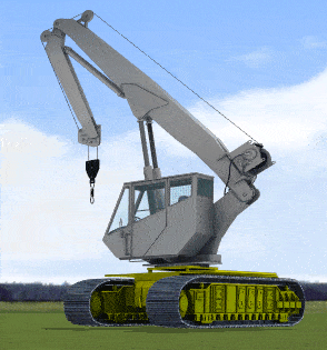 A gray crawler crane with a tracked base and a long boom arm is positioned on grass under a partly cloudy sky.